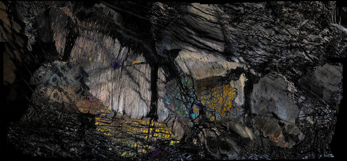 Close-up view of a textured rock surface with iridescent veins running through it